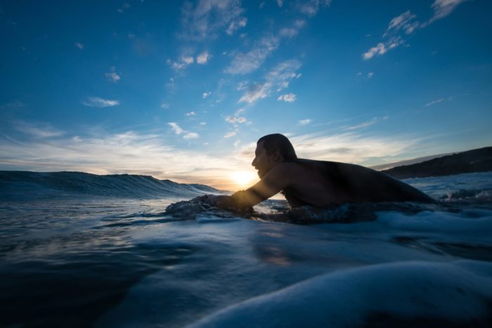 man surfing during blue hour
